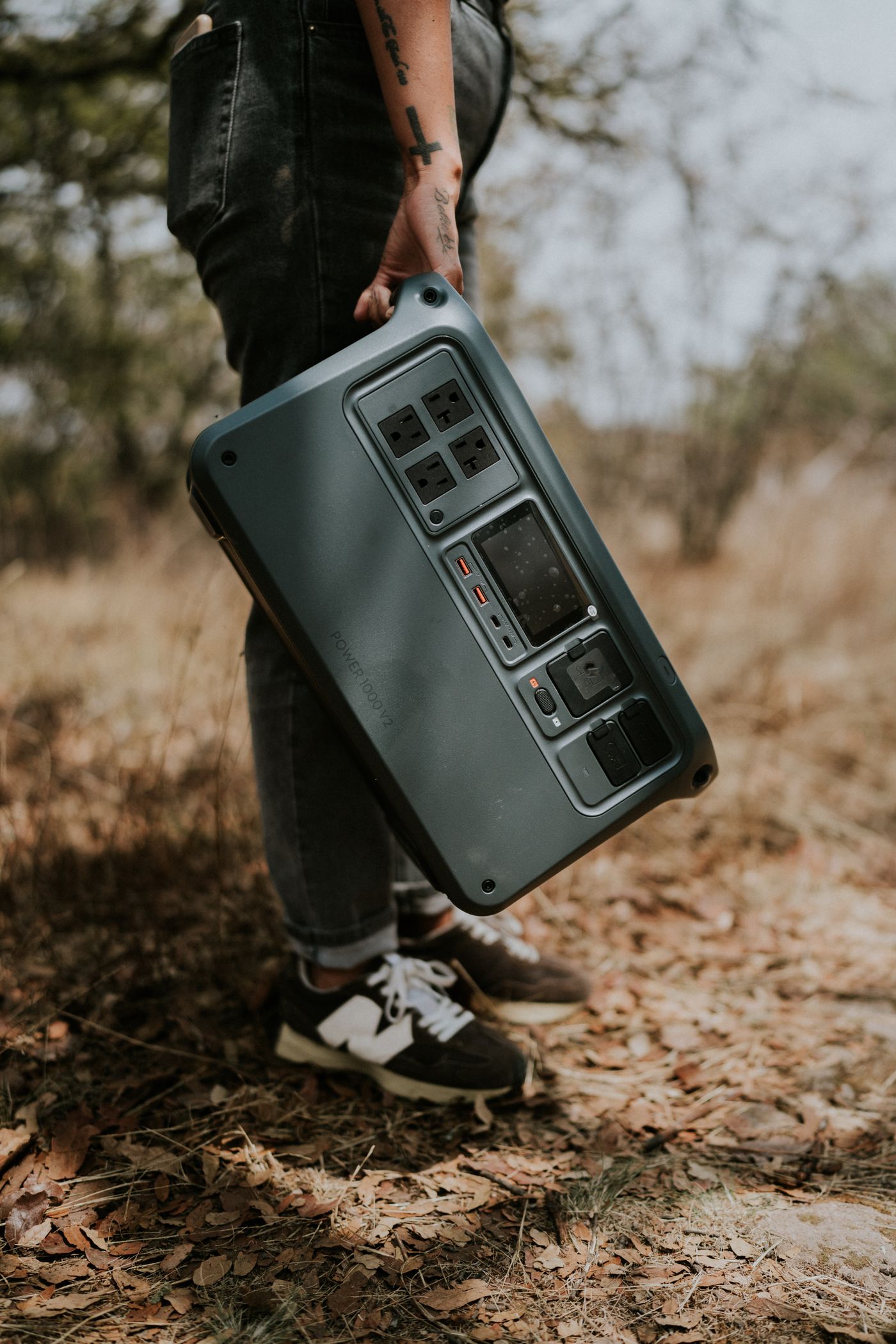 Person carrying a portable power station outdoors